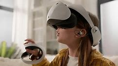 驚いたCaucasianの女の子の子供の女の子は、ホームプレイゲームコントローラで仮想現実ヘルメットを使用して3D世界メタバースでオンラインゲームをプレイし、VRメガネを着用してサイバースペースを探索します