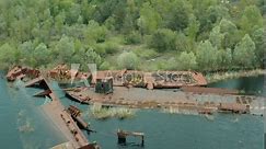 Aerial view of boat, ship and barge graveyard on the Pripyat river abandoned after Chernobyl disaster. Cemetery of ships and barges. Abandoned ships of Chernobyl. Pripyat river. Pripyat city.