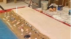 DIY Beach Desk Preview 🌊🦈🐚 . Transform your workspace with this stunning DIY beach desk! Made with concrete and epoxy resin, this desk features embedded sea shells and shark teeth, creating a mesmerizing shoreline effect. Watch the process and get inspired for your own project. Full video coming soon on our YouTube channel! 🌊🦈 #DIY #EpoxyResin #BeachHouseDecor | Stone & Timber