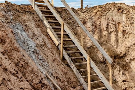 Premium Photo | Descent into a deep pit during the construction of the building Safety in ...