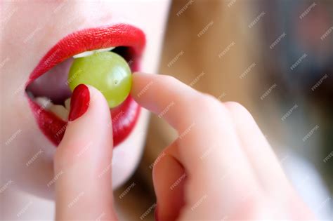 Premium Photo | Woman eating grape mouth with red lips close up