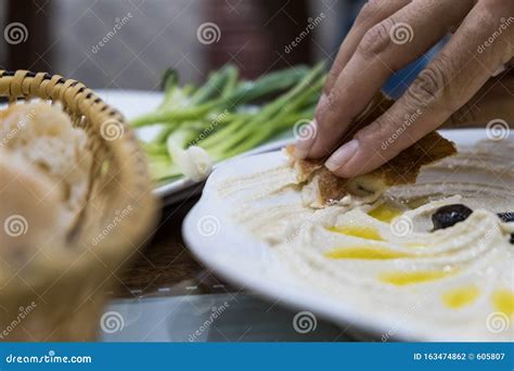 Female Hand Spreads Hummus on Pita Bread. Stock Photo - Image of ...
