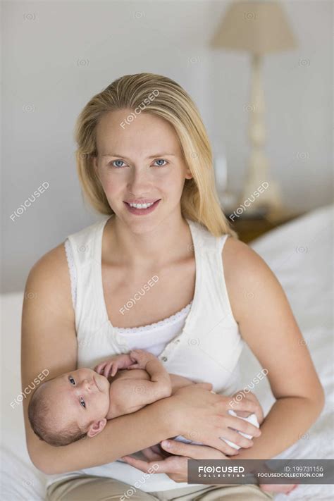 Mother cradling newborn baby on bed — pride, Waist Up - Stock Photo ...