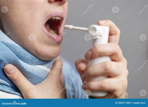 A Woman with a Sore Throat Sprays Medicine Aerosol Spray Down Her ...