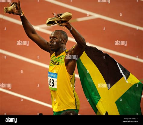 Jamaica's Usain Bolt holds up his golden shoes after setting a world ...