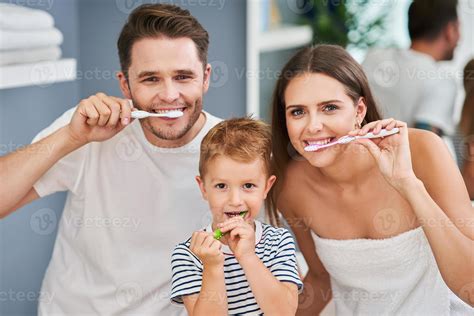 Portrait of happy family brushing teeth in the bathroom 15769741 Stock ...