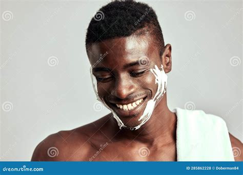Studio Portrait of Handsome Black Guy with Naked Torso Applying Cream ...