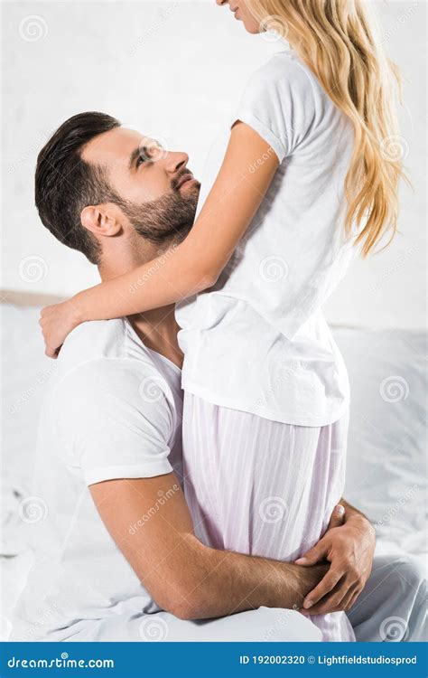 Young Couple Hugging on Bed at Home Stock Photo - Image of tender ...