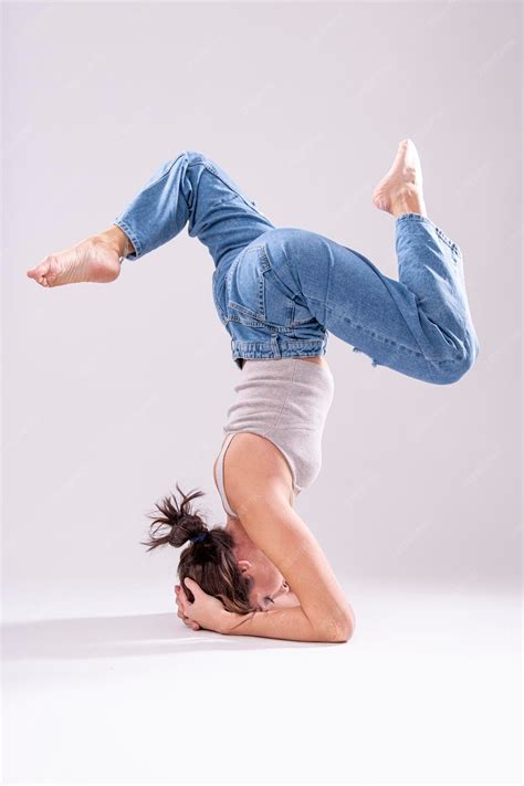 Premium Photo | Fit woman acrobat in jeans stretching her legs. acrobat ...