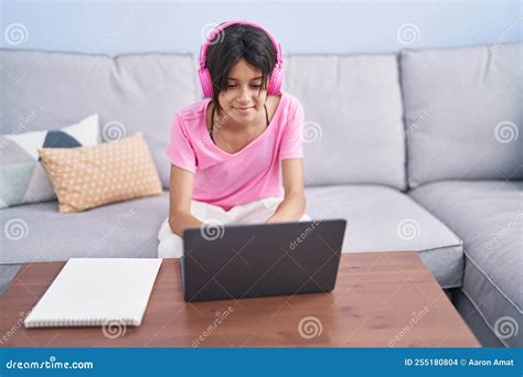 Adorable Hispanic Girl Sitting on Sofa Studying at Home Stock Photo ...