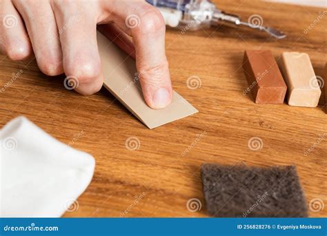 Man Filling Cracks, Scratches, Dents by Wax in the Wooden Floor ...