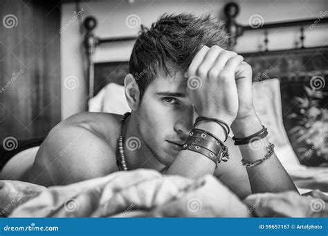 Shirtless Male Model Lying Alone On His Bed In His Bedroom, Looking At ...