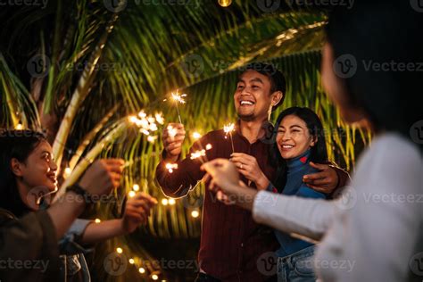 Portrait of Happy Asian group of friends having fun with sparklers outdoor - Young people having ...
