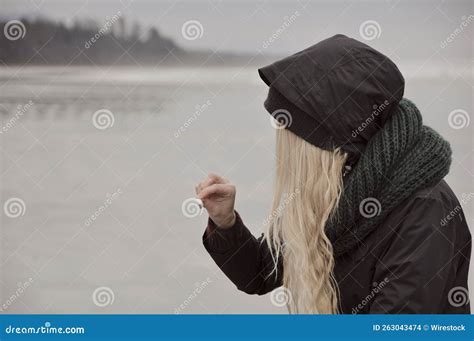 Young Blonde Girl Wearing Layers of Winter Clothing Near a Lake ...