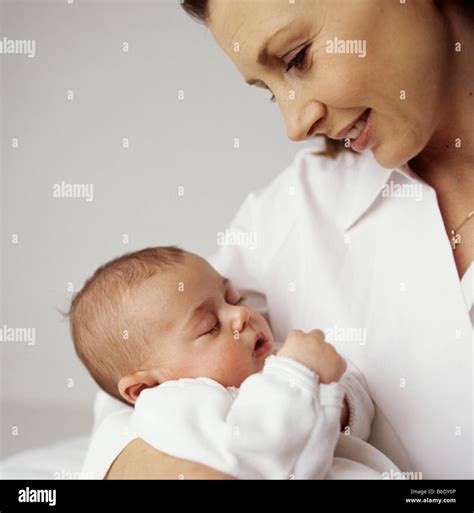 Mother and baby girl.12 week old baby girl asleep in her mother arms ...