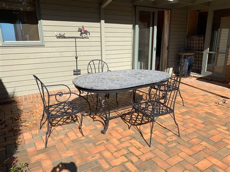 Lot - A cast iron and marble top outdoor table and four matching ...