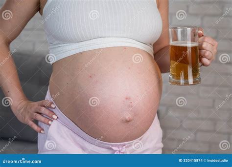 Faceless Pregnant Woman with Rash on Stomach Holding Glass of Beer ...