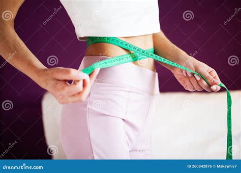Slim Young Woman Measuring Her Thin Waist with a Tape Measure at Home ...