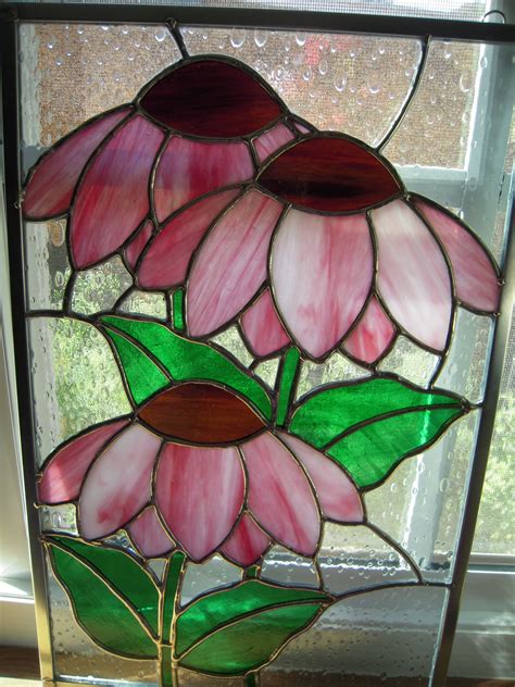 a stained glass window with three pink flowers