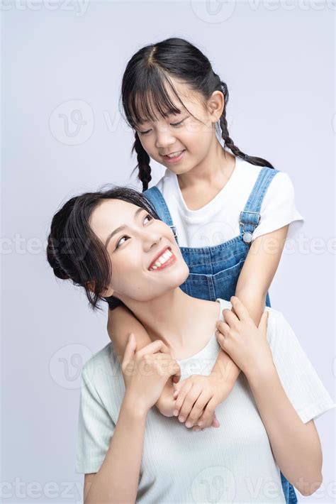 Image of Asian mother and daughter on background 20508396 Stock Photo at Vecteezy