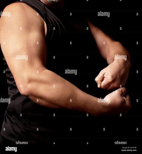 adult man with a sports figure in black clothes strained his muscles in ...