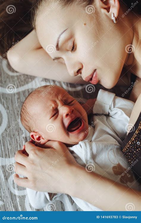 Woman Lie on Bed Together with Newborns. Mom and Baby. Boy Screams and ...