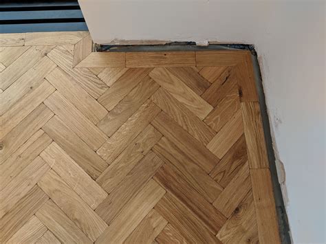 This parquet wooden floor is fitted in a herringbone design. It ...