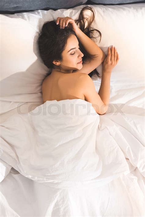 top view of beautiful nude woman sleeping in bed at home in morning ...