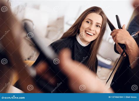 Female Hairdresser Straighten Brown Hair To Woman Using Hair Iron in ...