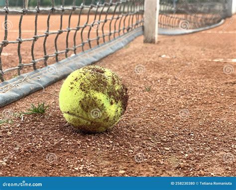 Dirty Lonely Tennis Ball by the Net at Clay Tennis Court. after ...
