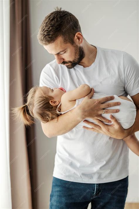 Premium Photo | A father is cradling his baby girl and putting her to sleep