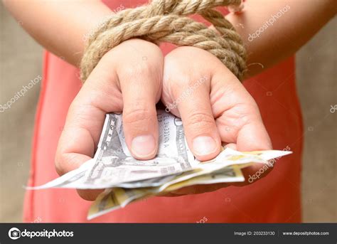 Women's hands tied with a rope and holding money. Credit bondage ...