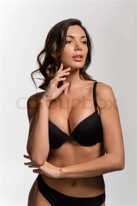 dreamy, sexy girl with big breasts touching face while looking away isolated on white | Stock ...