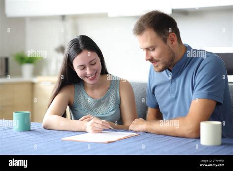 Happy interracial roommates or couple signing contract in the kitchen ...