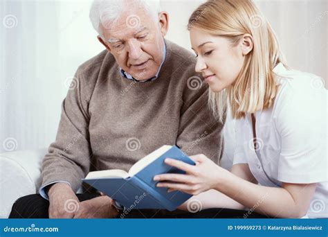 Blonde Volunteer Reading Book To Senior Man in Nursing Home Stock Image ...