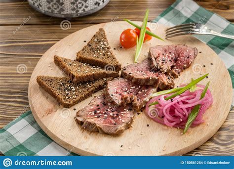 Slices of Roast Beef with Rye Bread and Red Onion on Wooden Table Stock ...