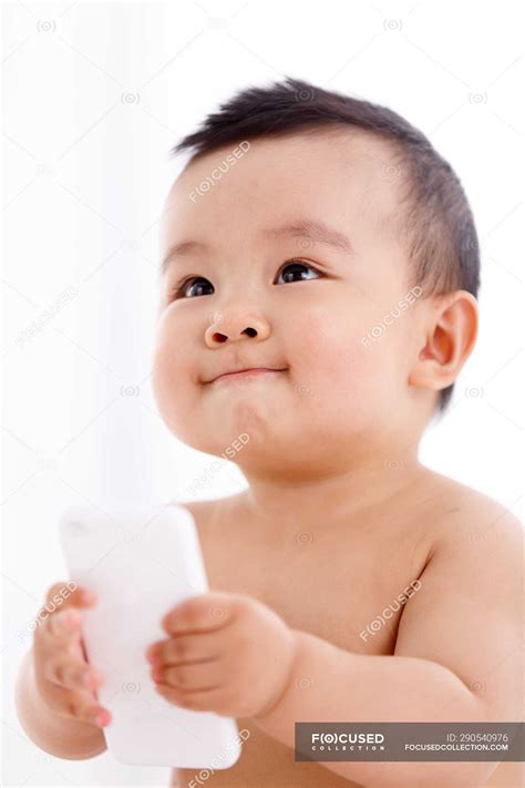 Cute asian baby boy holding smartphone and looking away — cheerful ...