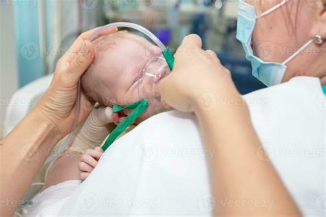 Baby with an oxygen mask in the neonatal unit.Baby wear oxygen mask ...