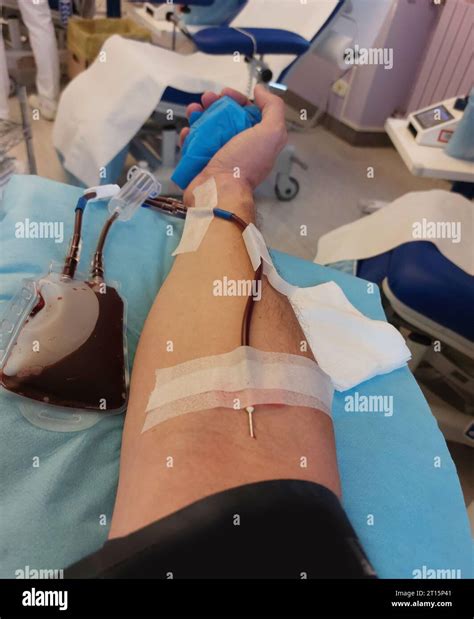 arm of young blood donor during blood transfusion for collection of blood plasma and platelets ...