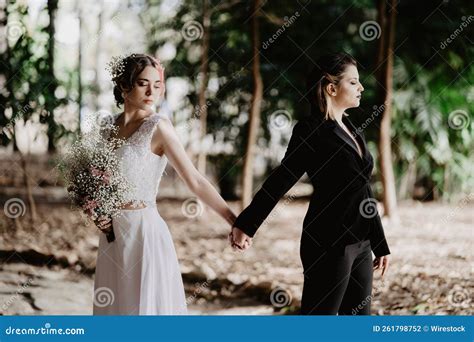 Hispanic Lesbian Couple Holding Hands in an Abounded Building with a Wedding Dress Stock Photo ...