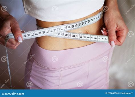 Slim Young Woman Measuring Her Thin Waist with a Tape Measure at Home ...