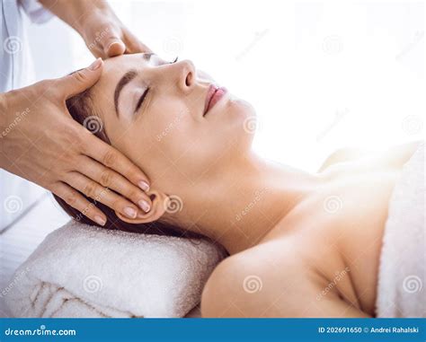 Beautiful Brunette Woman Enjoying Facial Massage with Closed Eyes in ...