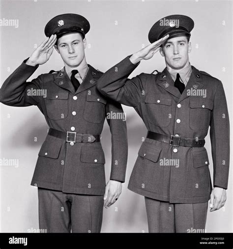 1940s TWO MEN IN ARMY UNIFORMS LOOKING AT CAMERA SALUTING JUST ENLISTED ...