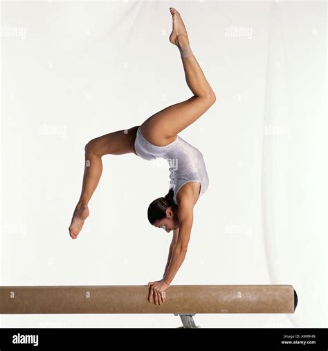 Young female gymnast on balance beam performing, side view Stock Photo ...
