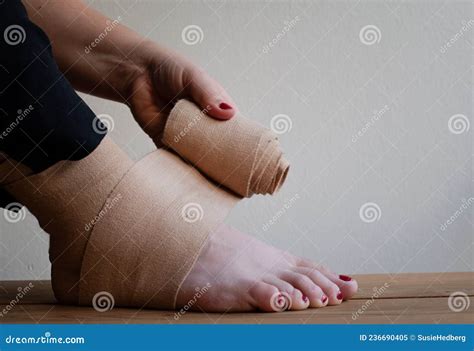 Woman Wrapping Elastic Bandage on Injured Foot, a Sprained Ankle. Stock ...