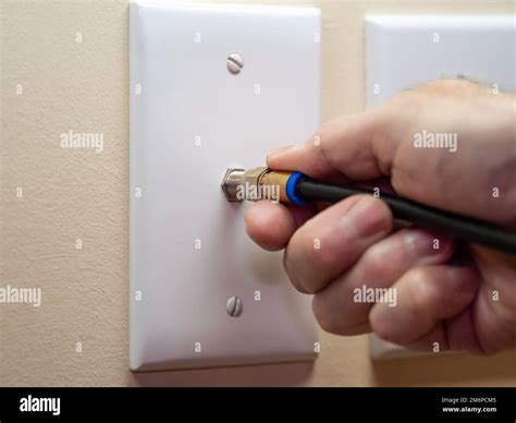 Male electrician connecting coax cable to wall outlet. Coaxial wire ...
