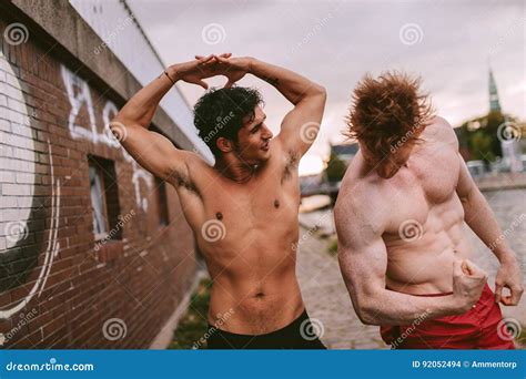 Two Young Men Flexing Their Muscles Outdoors Stock Photo - Image of ...