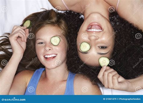 Teenage Girls Lying with Cucumbers Over Eyes Stock Image - Image of ...