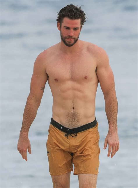 Liam Hemsworth curte praia com namorada e exibe tanquinho - OFuxico