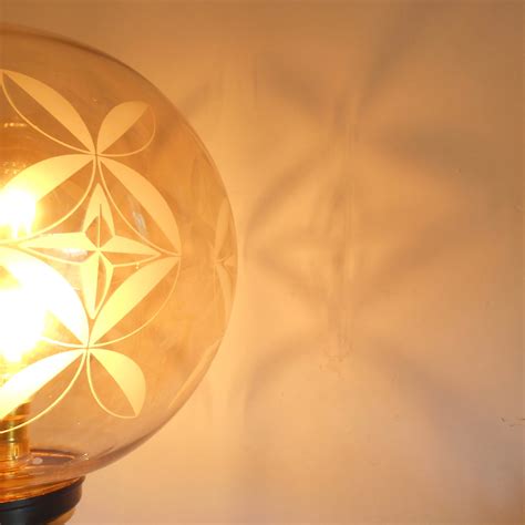 A gold and navy floor lamp with a vintage glass globe shade ...